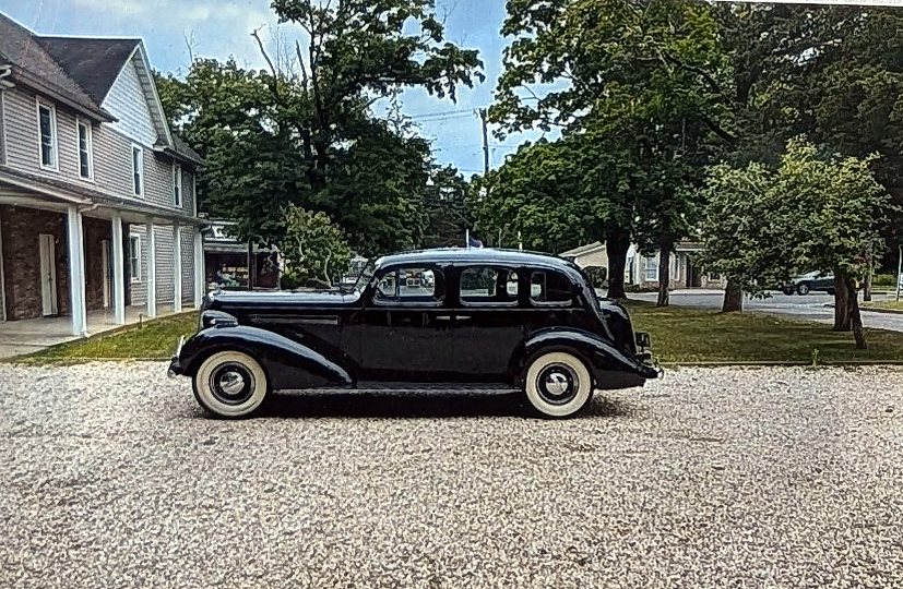 Driver-side profile of a black 1936 Buick Roadmaster four-door sedan