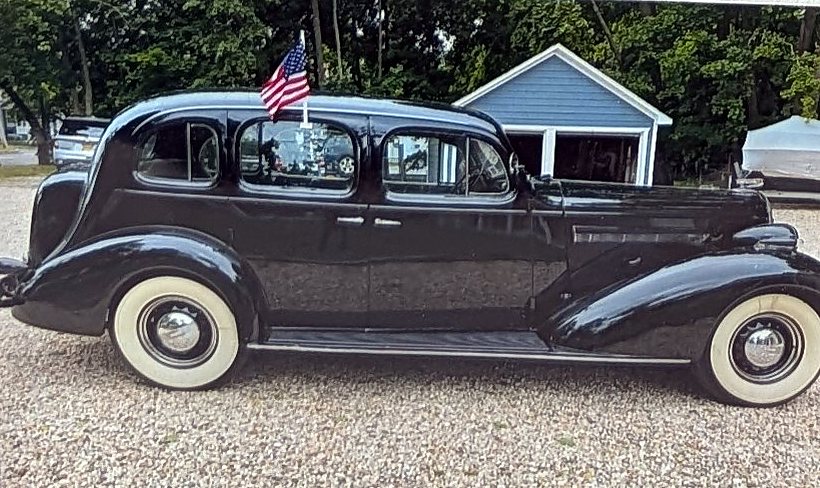 Passenger-side profile of a 1936 Buick Roadmaster sedan with wide whitewall tires and running boards